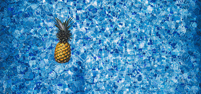 Un ananas flotte dans une piscine