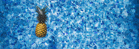Un ananas flotte dans une piscine