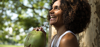 Une réunionnaise boit de l'eau de coco dans une noix de coco
