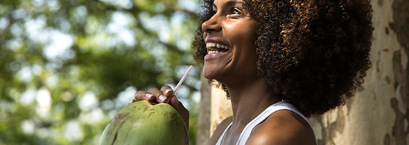 Une femme boit dans une noix de coco